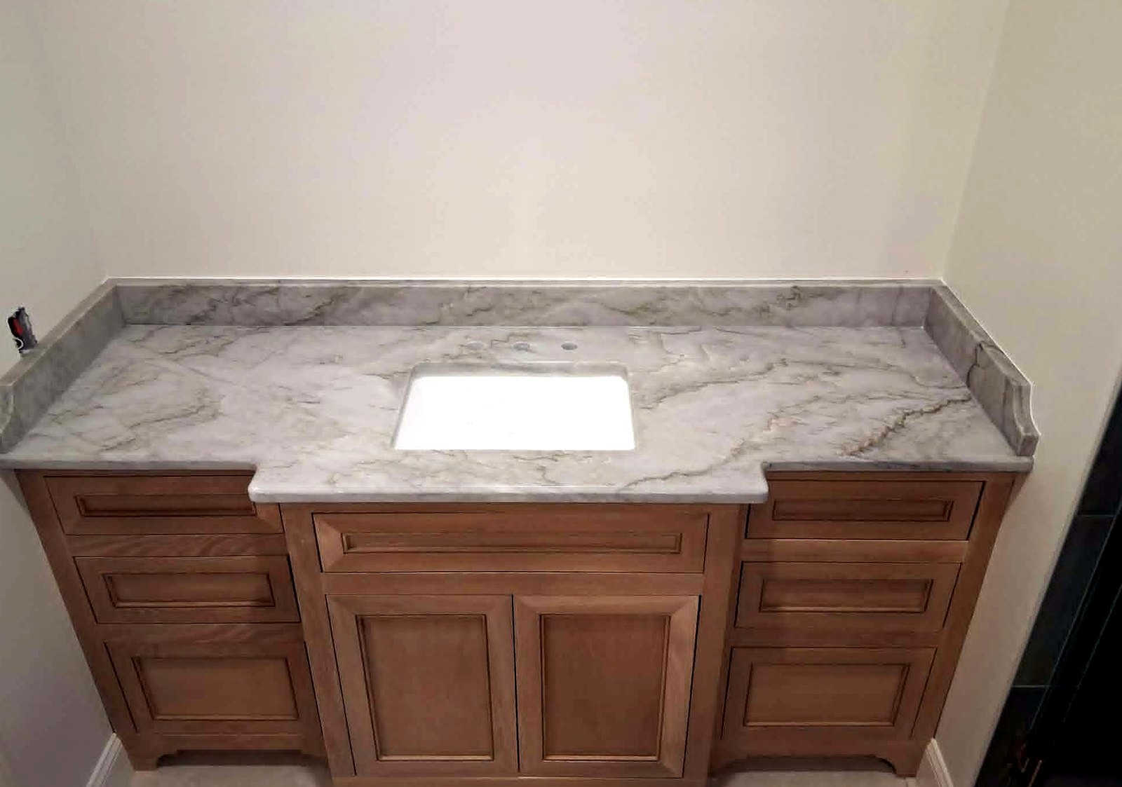 Gray marble vanity with wood cabinets